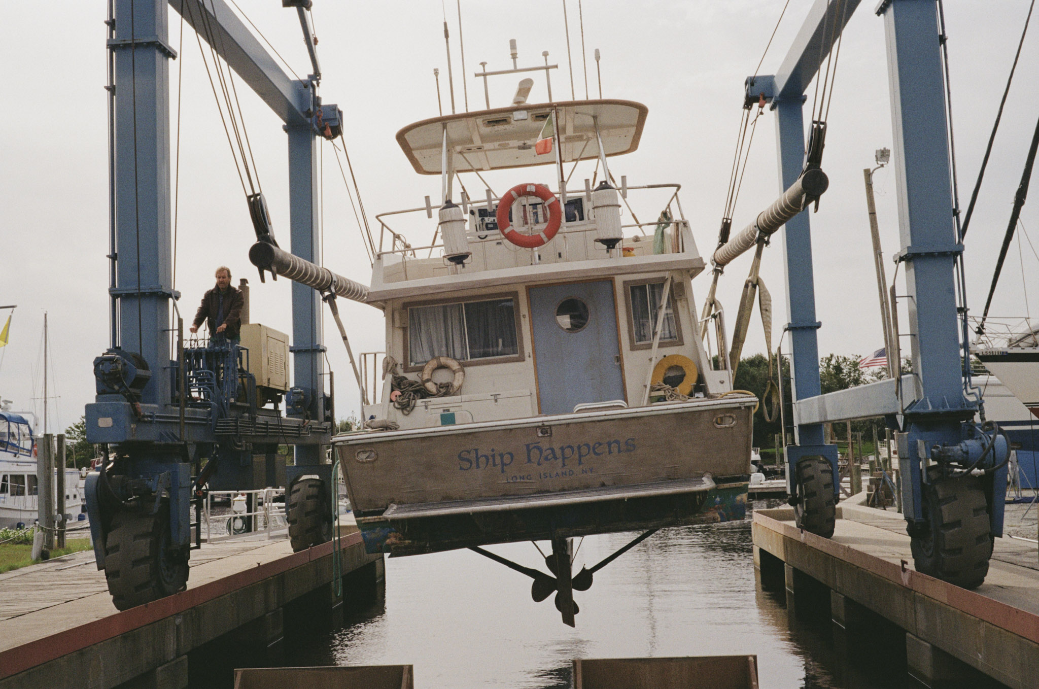 The family's boat, the Ship Happens, hoisted in a marina travel lift — Long Island, NY